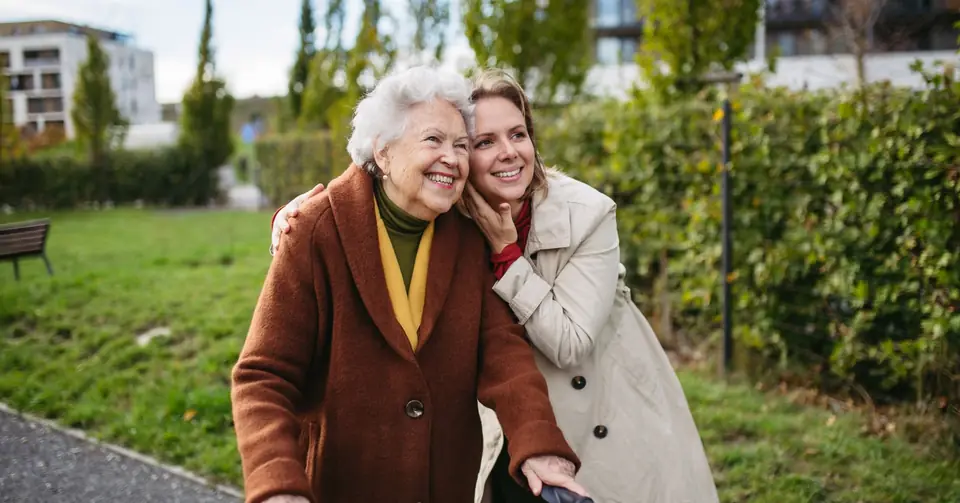 Betreuungskraft und Seniorin beim Spaziergang